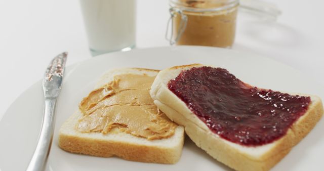 Close up view of peanut butter and jelly sandwich in a plate with copy space on white surface. food and nutrition concept