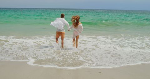 Carefree Couple Enjoying Beach Day by Ocean Waves