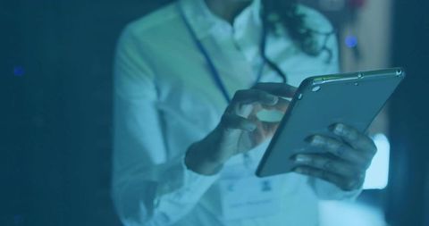 Professional technician using tablet in high-tech control room