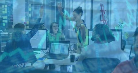 Diverse Team High-Fiving Over Data Analytics With Stock Market Overlay in Modern Office