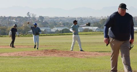 Community baseball players and umpire walking across infield showing teamwork and focus