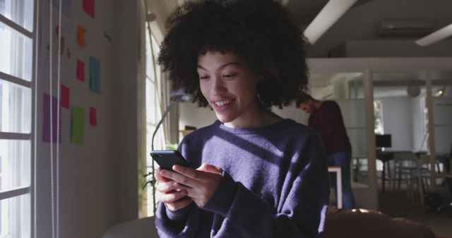 Young Woman Smiling While Using Smartphone in Modern Office - Download Free Stock Images Pikwizard.com