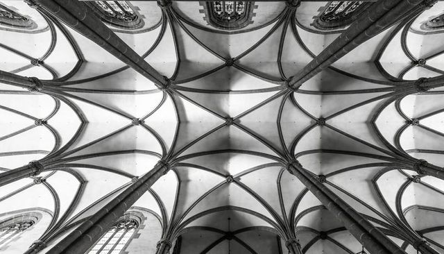 Gothic ribbed vaulting forming geometric patterns of pointed arches in cathedral ceiling