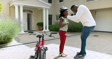 Father Teaching Daughter to Ride Bike Outdoors