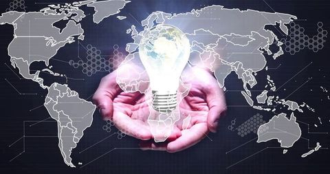 Cupped hands holding glowing earth light bulb over digital world map global energy innovation