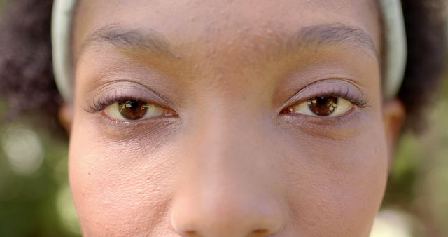 Eyes closeup of african american woman standing in sunny garden. Free time, weekend, vacations and summer, unaltered.