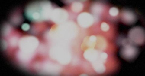 Abstract blurred colorful moving spots over black background