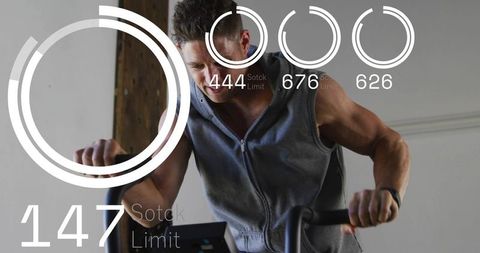 Muscular man pedaling on indoor bike wearing wrist tracker with fitness hud overlay