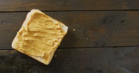 Close-Up of Toast with Creamy Peanut Butter on Rustic Wooden Table - Download Free Stock Images Pikwizard.com
