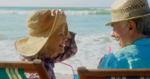 Senior Couple Enjoying Refreshing Drinks by Ocean