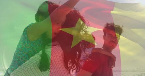 Family enjoying beach piggybacks with cameroon flag overlay, summer togetherness