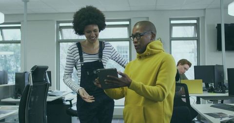 Two Colleagues Collaborating on Digital Content in Modern Office