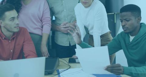 Team reviewing documents discussing strategy and project planning in modern office