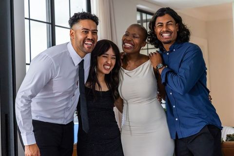 Diverse friends laughing and posing in modern living room celebrating friendship and joy