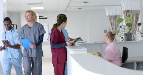 Medical Professionals Collaborating at Hospital Reception Desk