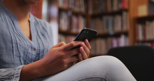 Young Person Using Smartphone in Library - Download Free Stock Images Pikwizard.com