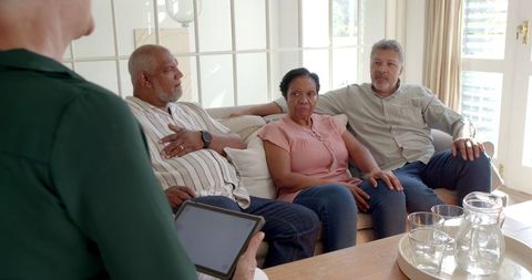 Senior couples consulting with financial advisor at home using technology