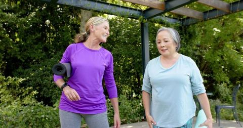 Smiling Senior Women Leaving Outdoor Yoga Class with Mats
