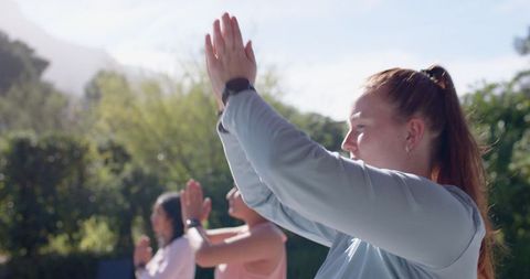 Diverse Group of Women Practicing Yoga Outdoors in Bright Sunlight