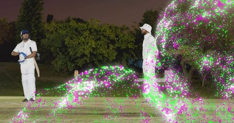 Night cricket batter standing at crease with neon magenta and green light trails