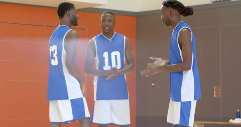 African american basketball players clapping during pregame ritual on indoor court