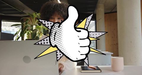 Curly-haired woman typing at coworking desk with pop-art thumbs-up overlay and laptop