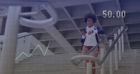 Busy professional checking smartwatch while descending urban stairs with smartphone and tote