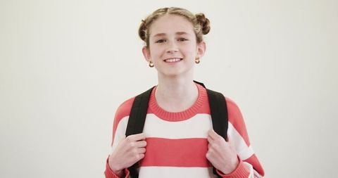 Smiling child with backpack in casual striped sweater