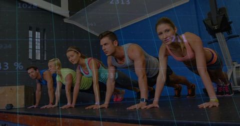 Five adults performing planks on raised platform in gym training session