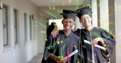 Joyful graduates celebrating together in caps and gowns holding red ribboned diplomas