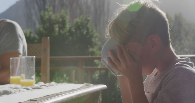 Young Boy Drinking from Bowl Outdoors in Morning Light - Download Free Stock Images Pikwizard.com