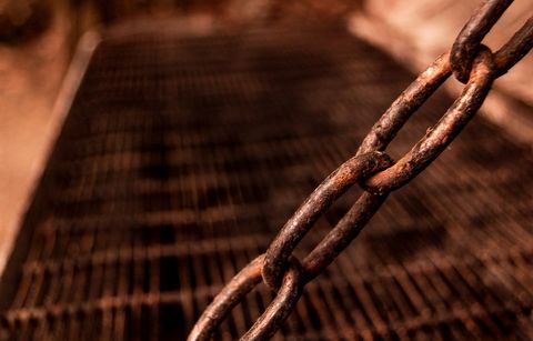 Rusty Chain on a Metal Grate with Blurred Background