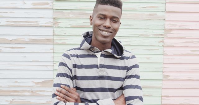 Confident Smiling Young Man with Striped Hoodie Against Pastel Wall - Download Free Stock Images Pikwizard.com