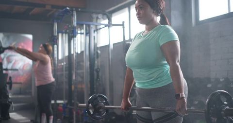 Black Women Partner Weightlifting in Industrial Gym Lifting Barbell for Strength Training