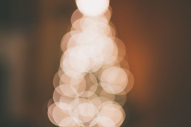Warm-toned blurry Christmas tree lights forming bokeh effect, perfect for holiday-themed cards, social media posts, invitations, and advertisements. Ideal for creating a cozy and festive atmosphere in various design projects.