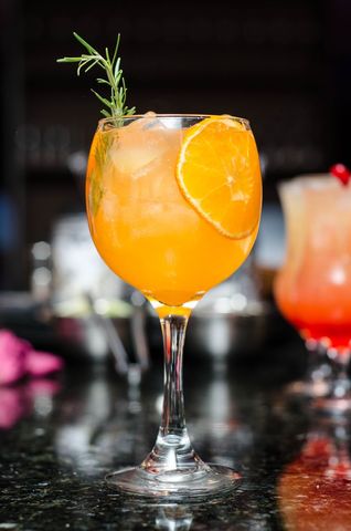 Refreshing Orange Cocktail with Rosemary Garnish on Bar Counter