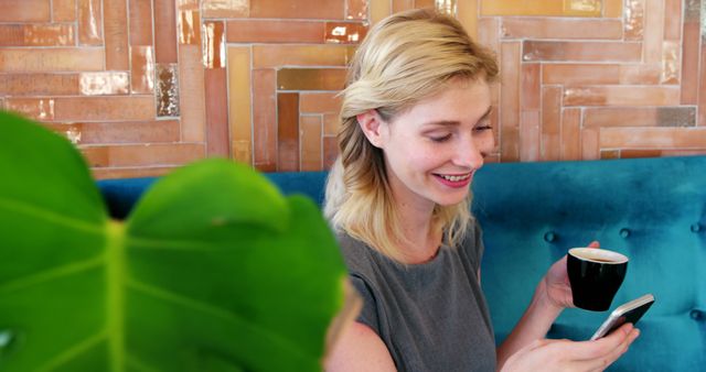 Smiling Woman Enjoying Coffee and Smartphone in Stylish Cafe - Download Free Stock Images Pikwizard.com