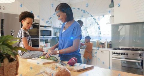 Mother chopping cucumber in modern kitchen with family helping and smart home data overlay