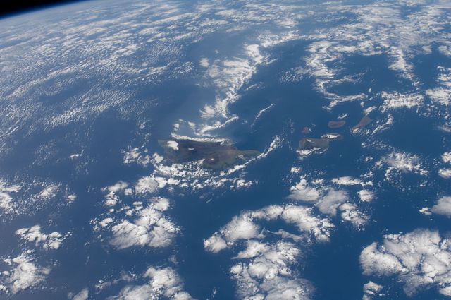 A high-resolution view of the Hawaiian Islands taken from the International Space Station on December 29, 2011. The picture prominently shows the Big Island surrounded by the vast Pacific Ocean and scattered clouds. Perfect for geographical, educational, or environmental presentations, or as a captivating visual in travel promotions and nature-related publications.