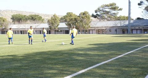 Soccer team practicing passing drills on sunny school field