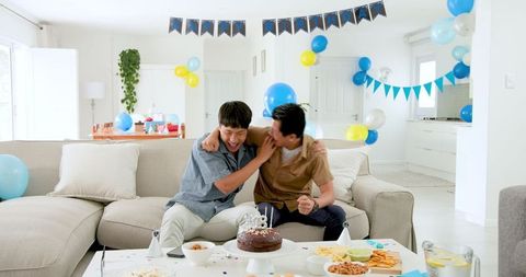 Asian Father and Son Celebrating Birthday in Bright Home Setting