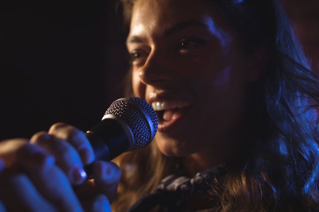 Close up of enthusiastic female singer performing in nightclub