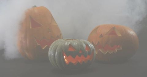 Glowing jack-o'-lantern trio emitting warm candlelight and fog for halloween decor
