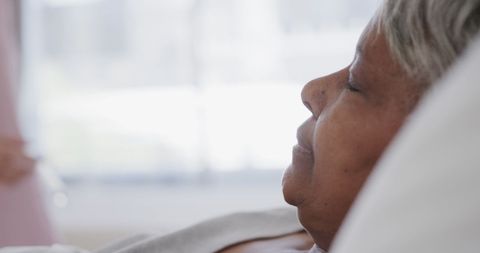 Elderly Woman Patient Resting in Hospital Bed