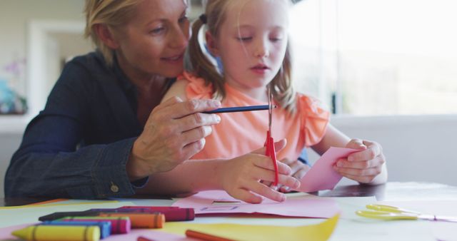 This lively composition captures a mother assisting her daughter with arts and crafts at home. Useful for illustrating the significance of family bonding, educational activities, and child development. Ideal for use in parenting blogs, educational websites, and advertisements promoting creative and educational toys or supplies.