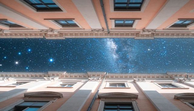 Milky way revealing narrow courtyard framing symmetrical historic facades at night