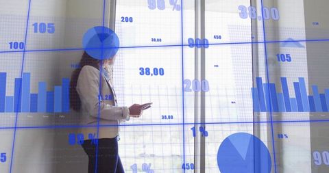 Businesswoman holding smartphone viewing blue data charts and analytics on office glass
