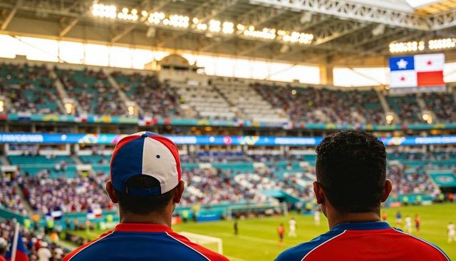 Two fans watching panama soccer match from stands wearing red and blue jerseys