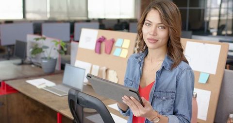 Confident businesswoman holding a tablet in modern office