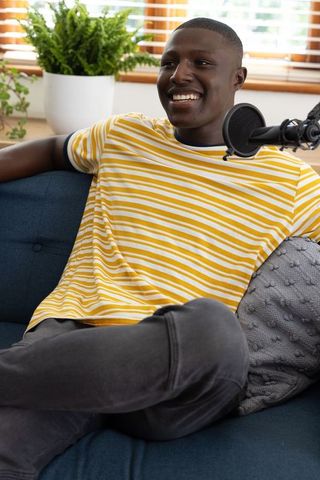 Smiling podcaster engaging audience in cozy home studio